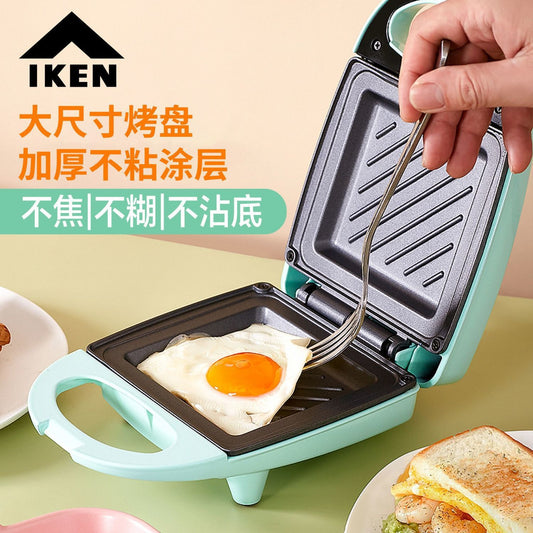 IKEN multifunctional sandwich maker cooking an egg with a non-stick surface and easy-to-use design.